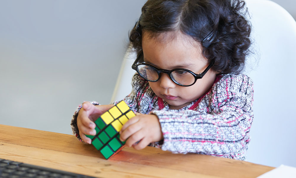 Little Girl Playing with Rubik's Cube