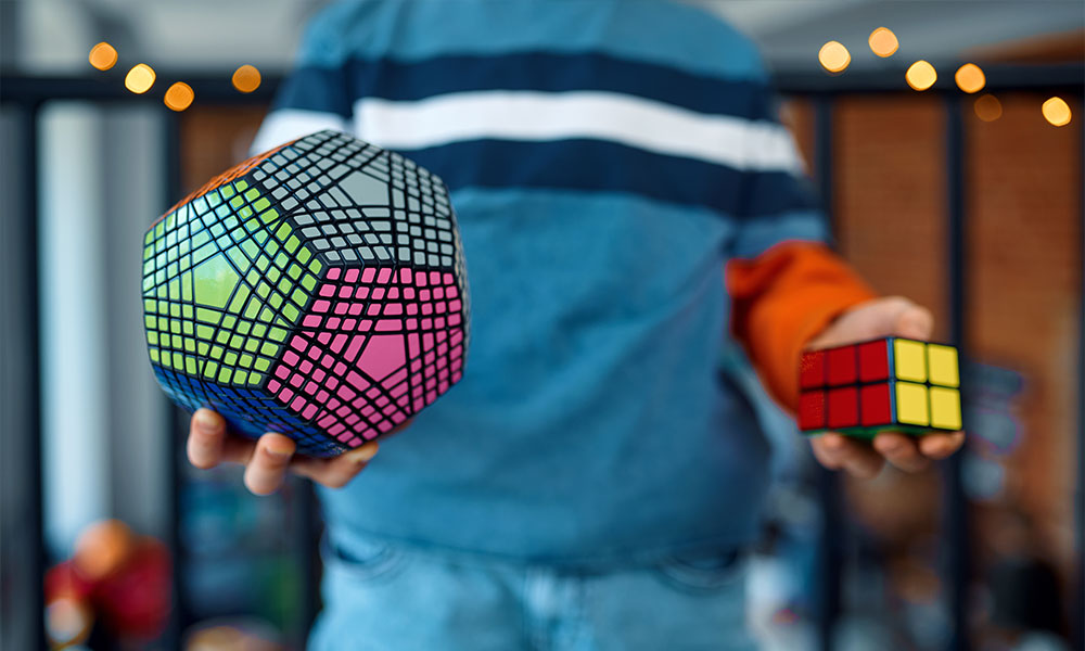 Little Boy Holding Two Rubik's Cubes