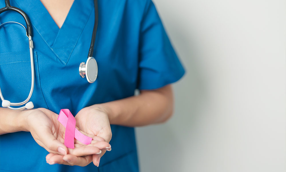 Doctor Holding Pink Ribbon for Breast Cancer Awareness